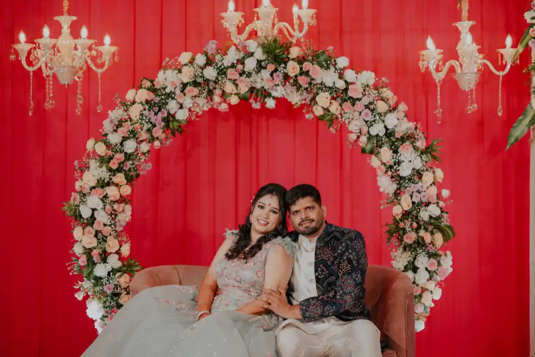 Couple on red floral ring stage by Best Wedding Planners in Bangalore