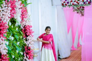girl posing beside elegant floral backdrop with pink drapes
