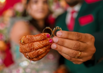 Close-up of bride and groom holding wedding rings in their engagement ceremony - Wedding Photographers in Bangalore