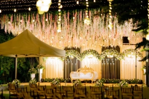 Luxurious wedding reception hall with golden chandeliers and floral ceiling decor.