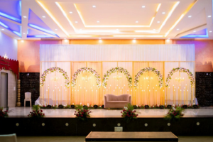 Wedding hall with golden lighting and pastel floral backdrop - best wedding event organisers in bangalore