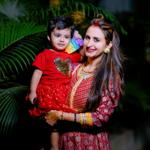 Mother in festive attire holding her child during wedding celebration in Bangalore